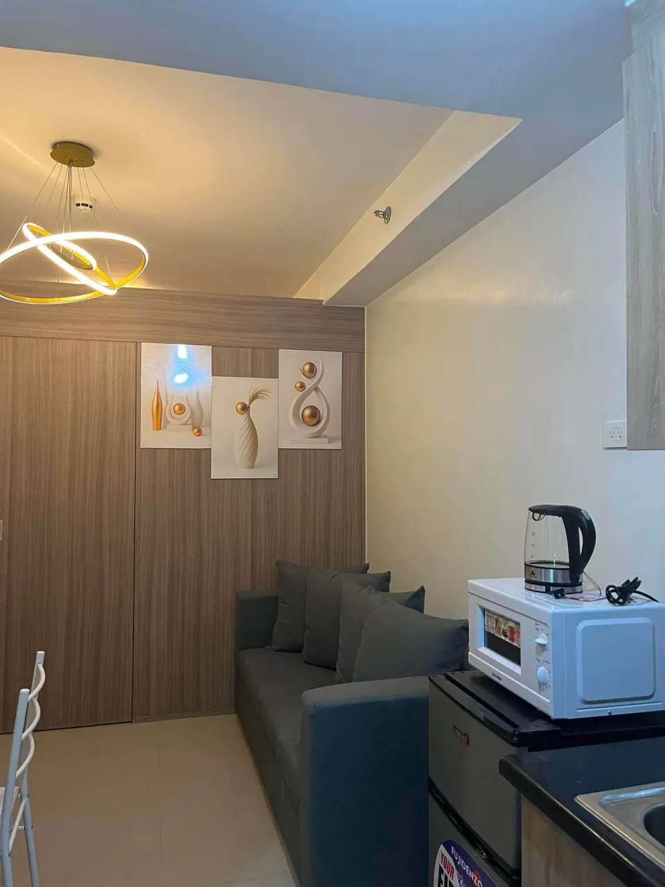 Sofa, kitchen counter and a small refrigerator