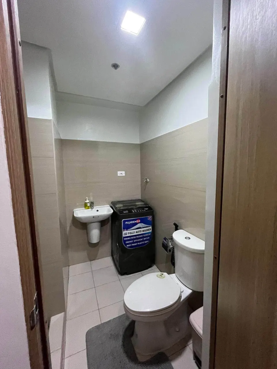 Bathroom with a toilet, a sink and a washing machine