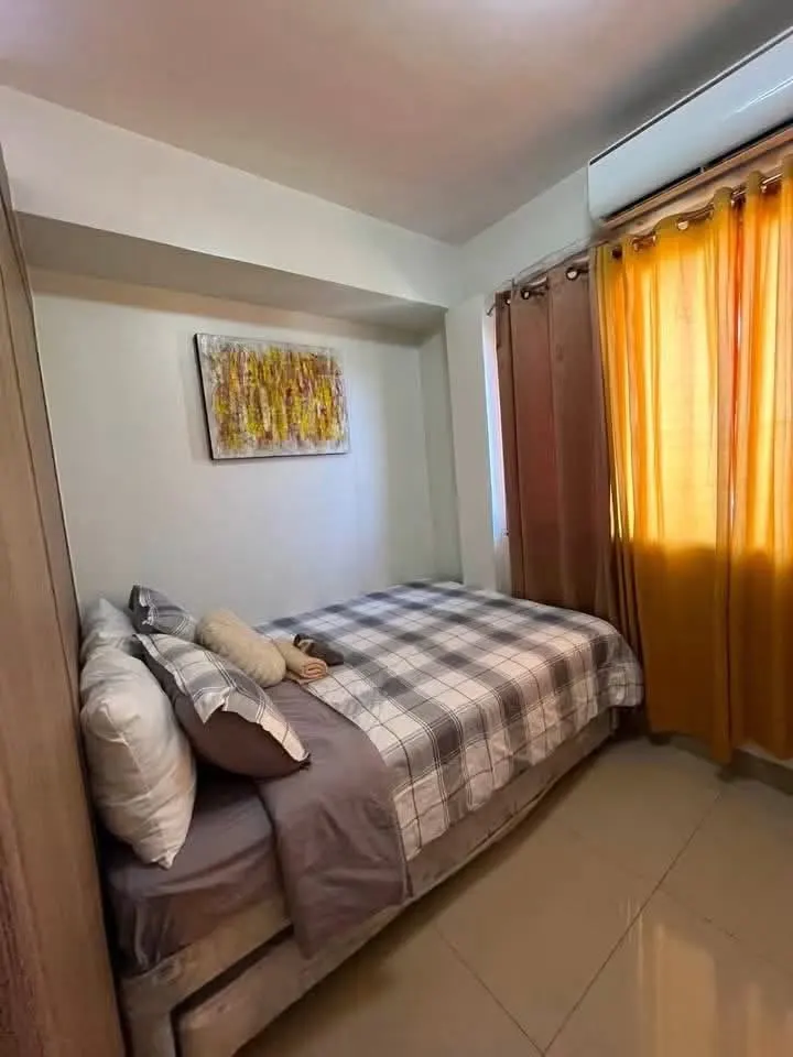 Double bed with plaid linen and warm curtains