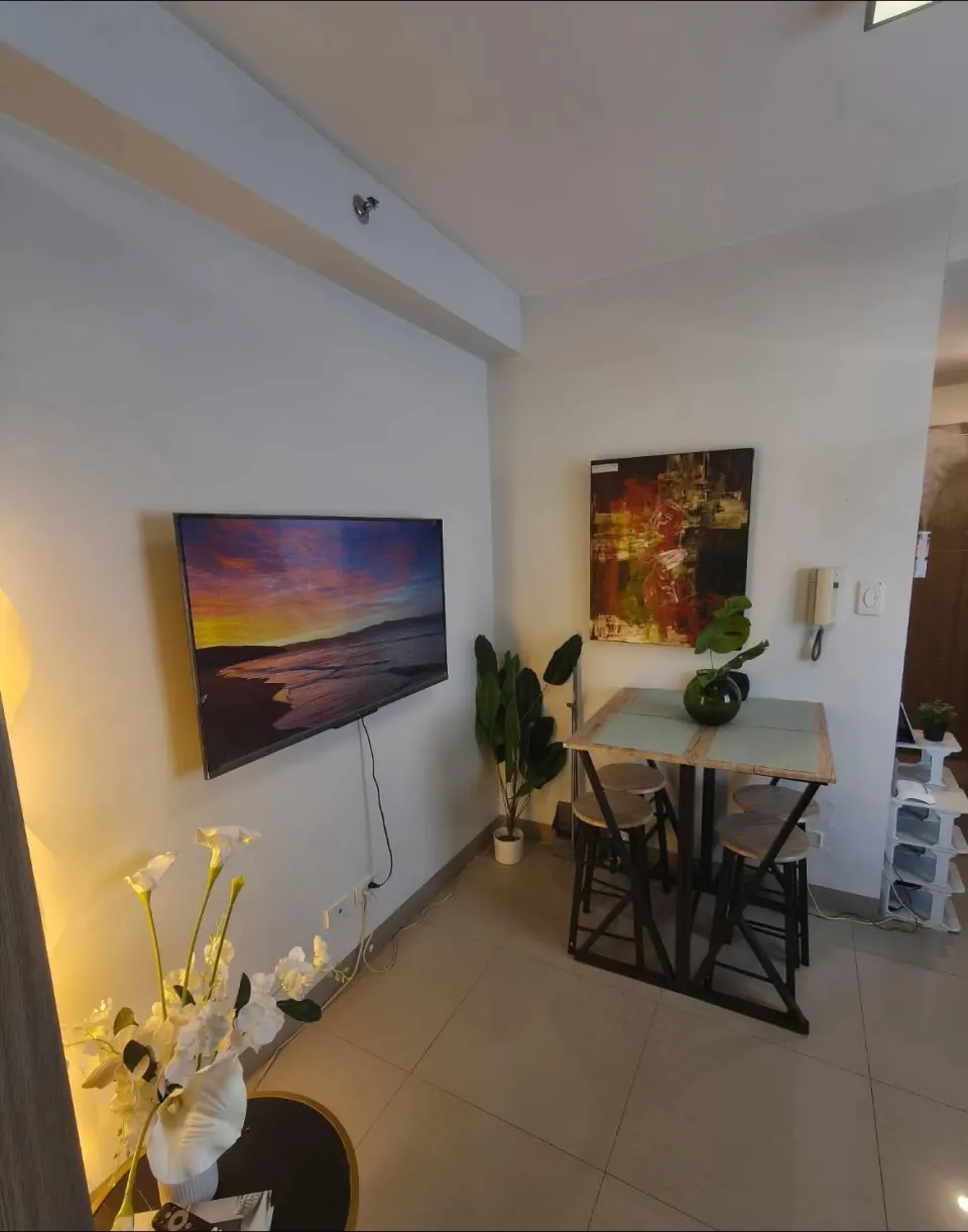 Smart TV on the wall beside a small dining table