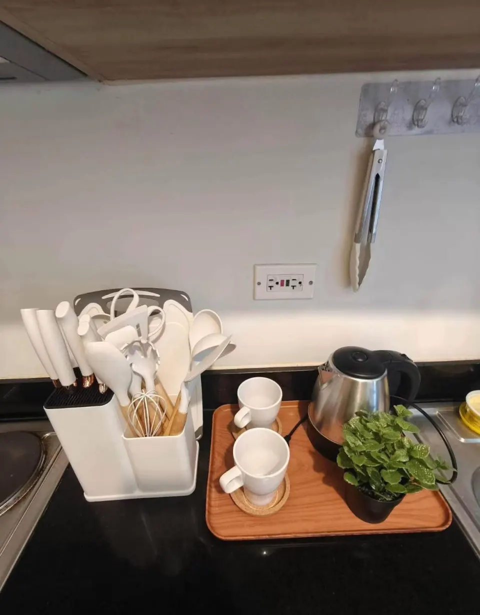 Tea and coffee tray with mugs, an electric kettle and kitchen utensils