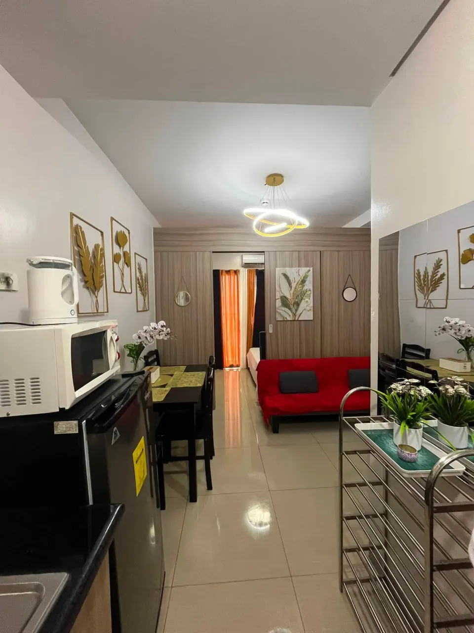 View along the unit past the microwave and refrigerator to the living area